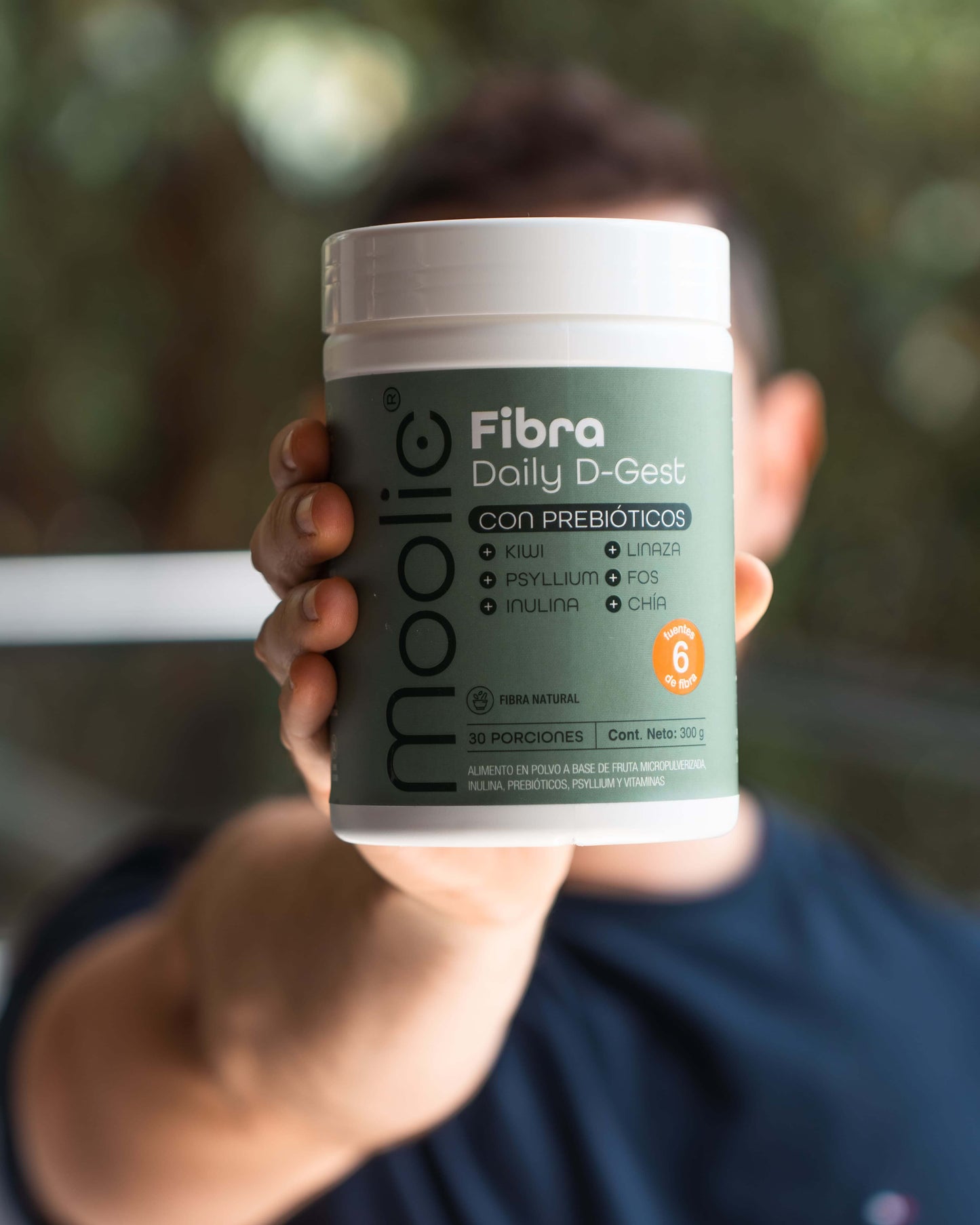 Mezcla de fibras naturales Moolic con FOS y chía para tránsito intestinal con modelo sosteniendo el tarro