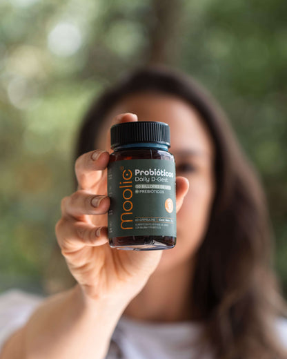 Botella de Moolic Probióticos sobre superficie neutra en toma frontal con modelo